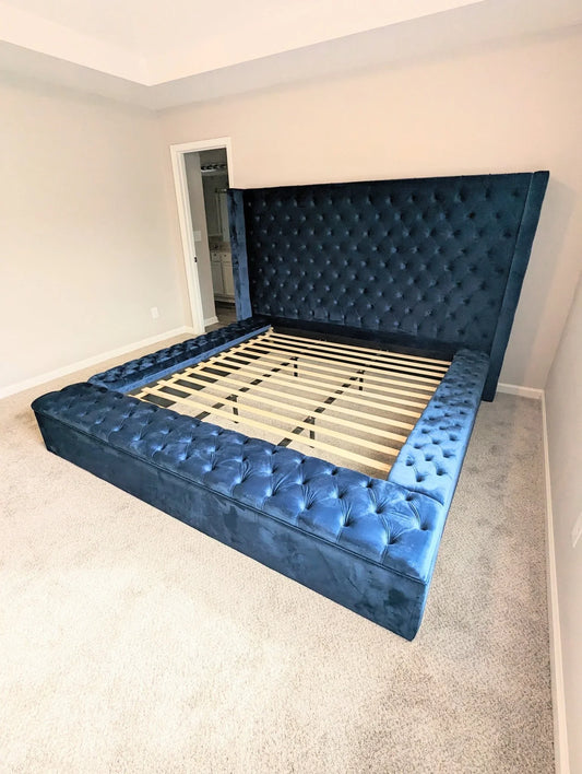 Navy blue velvet tufted bed frame with an extra tall headboard and wooden slats