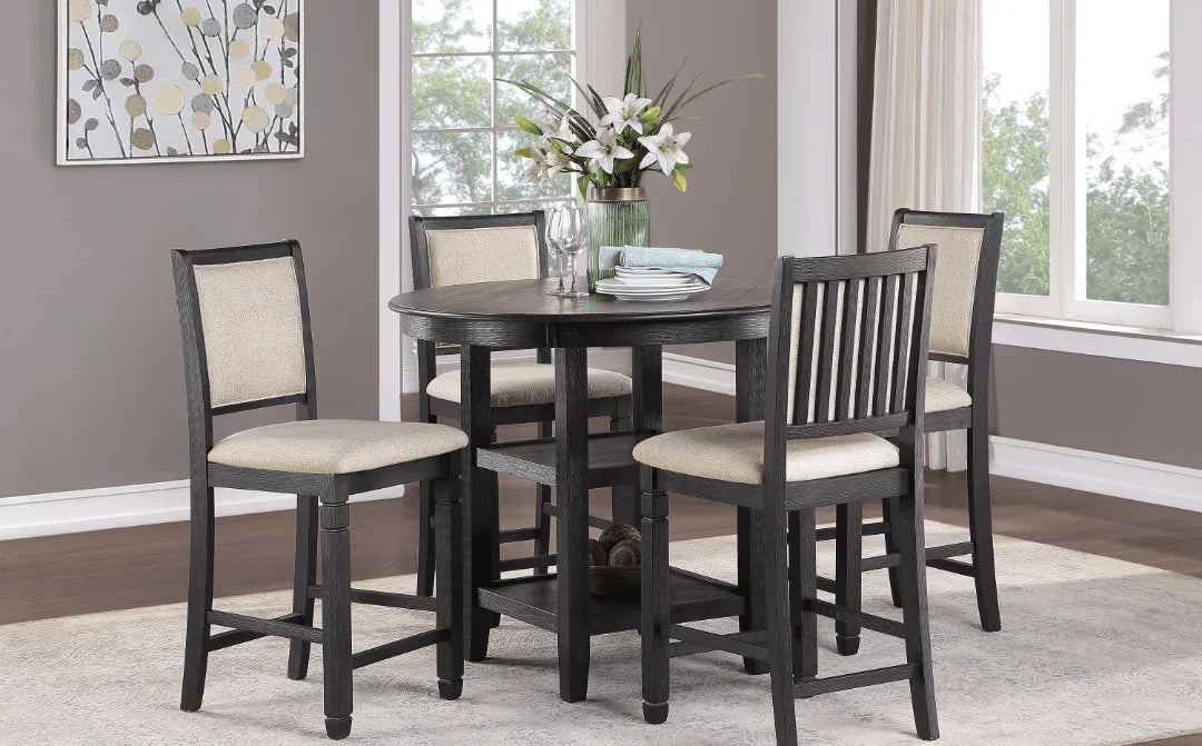 Black wood counter-height dining set with four beige upholstered chairs around a round table.
