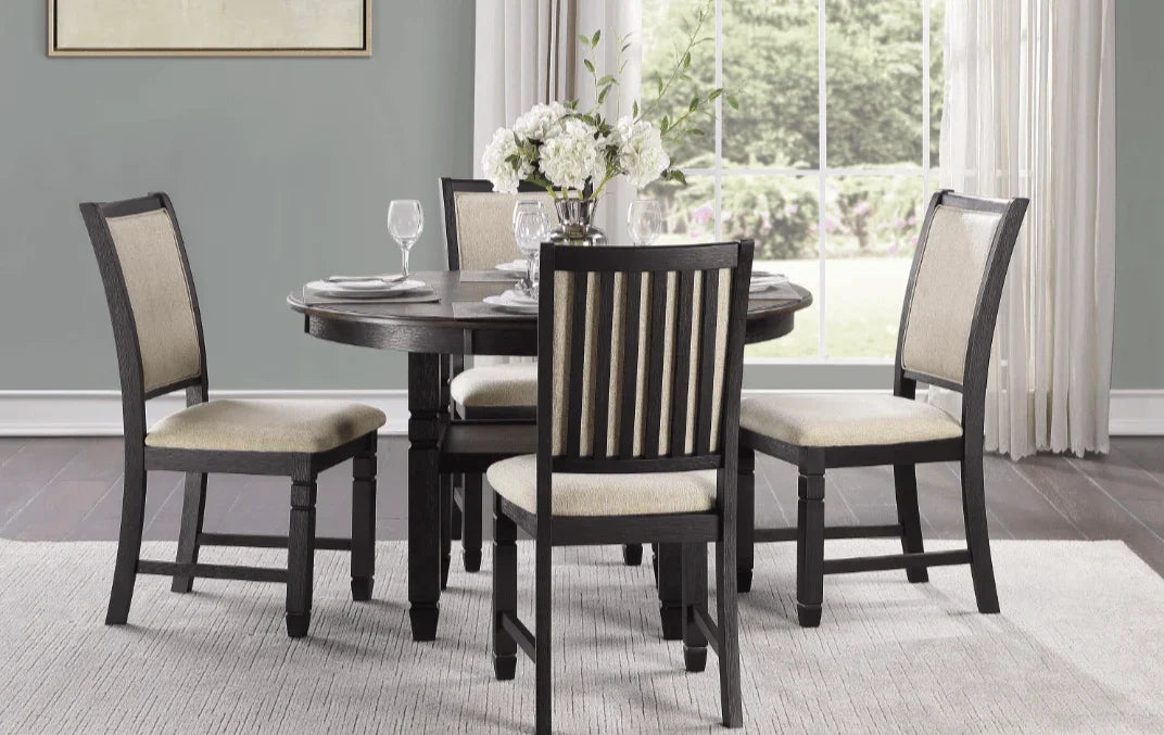 Dark wood round dining table set with four beige upholstered chairs in a modern room