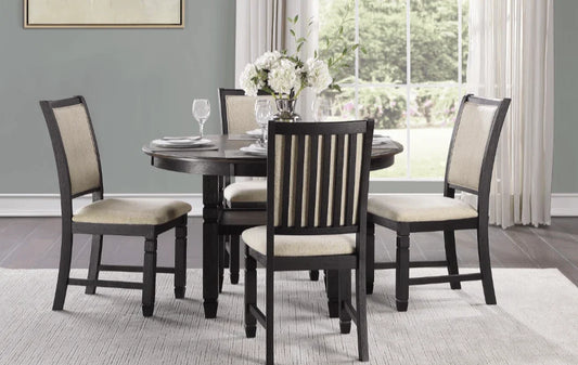 Dark wood round dining table set with four beige upholstered chairs in a modern room
